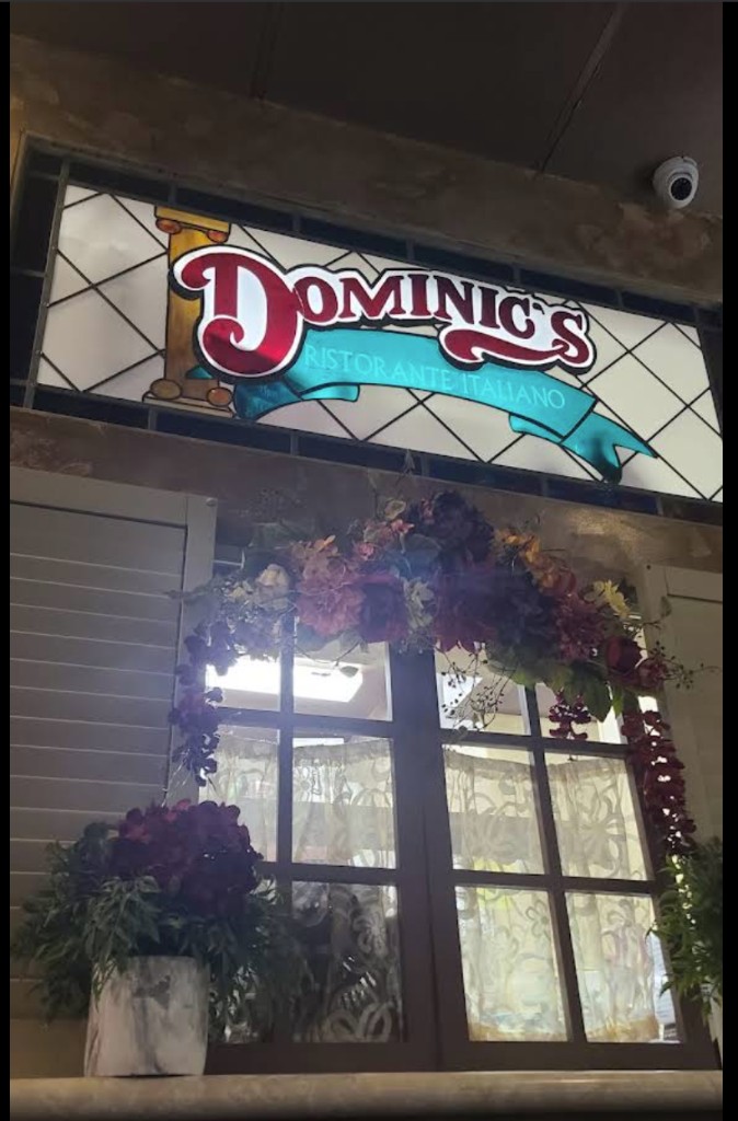 Dominic's Ristorante Italiano entrance with stained-glass sign and floral arch